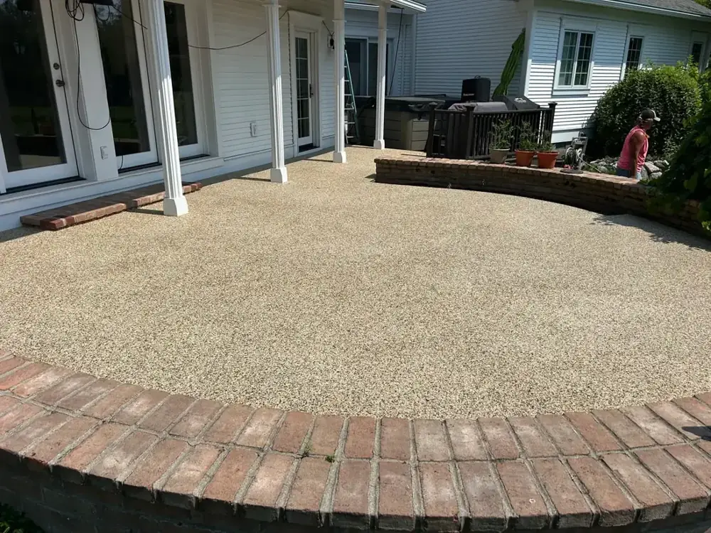 Round resin bound patio with a brick edge beside a house